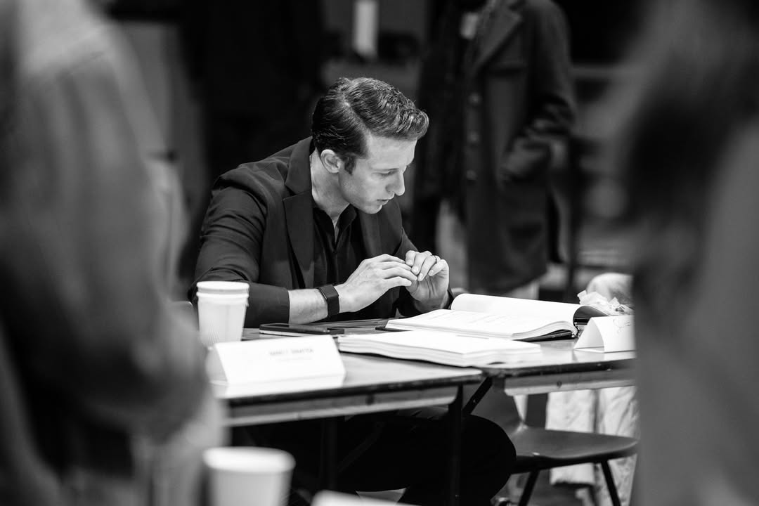 An actor reading at a table during Sinatra the Musical preparations