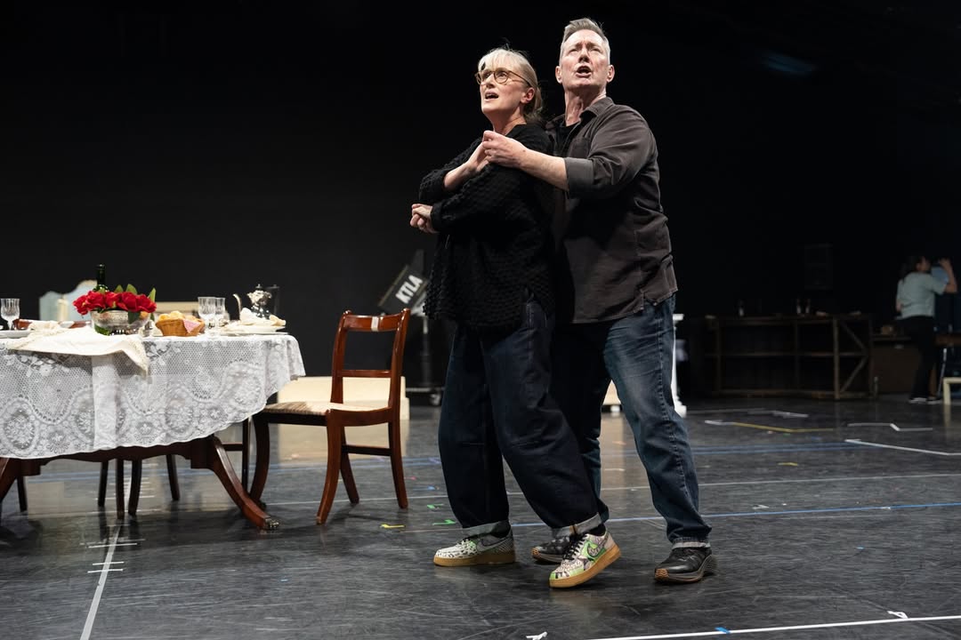 Two performers rehearsing a scene together on a set